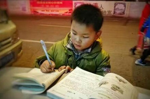 河南8歲男孩寒夜趴垃圾桶上寫(xiě)作業(yè) 常幫母親照看攤位.